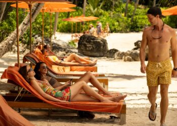 Aimee Lou Wood, Charlotte Le Bon and Patrick Schwarzenegger on the beach on set in The White Lotus season 3