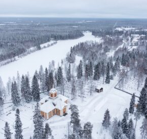 Image shows aerial view of snowy surroundings of the Ylikiiminki church