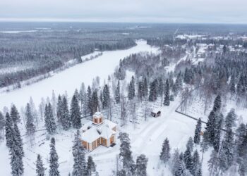 Image shows aerial view of snowy surroundings of the Ylikiiminki church