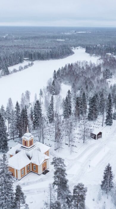 Image shows aerial view of snowy surroundings of the Ylikiiminki church