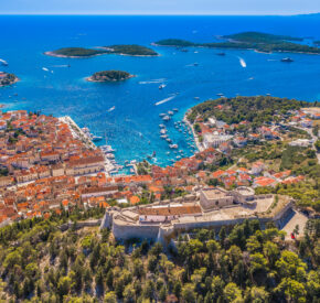 The old town of Hvar, Croatia, basking in the sunlight with the bright blue waters of the Adriatic in the background