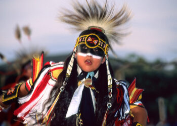 A boy dressed in traditional regalia dances at the Milk River Indian Days powwow