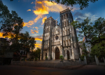 St. Joseph's Cathedral in Hanoi at sunset. The building looks like a gaudy, mini Notre Dame