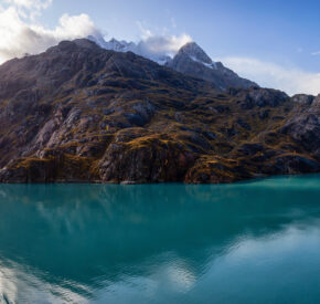 A panoramic view of the mountain landscape on the ocean coast during a cloudy and colourful morning in fall season, Glacier Bay, Alaska