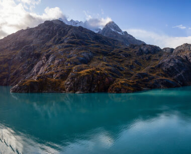 A panoramic view of the mountain landscape on the ocean coast during a cloudy and colourful morning in fall season, Glacier Bay, Alaska