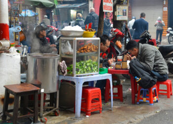 Customers eat at a street food stall in the historic old quarter of Hanoi