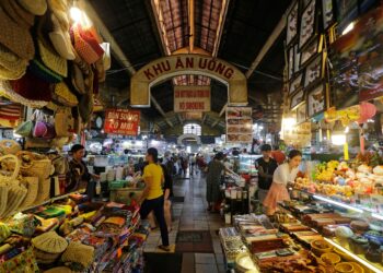 Tourists examining knickknacks within Ben Thanh Market