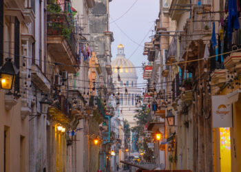 Historic buildings on Teniente Rey Street with Cuba Capitol building at the back in Old Havana