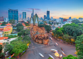 Aerial view of Notre-Dame Cathedral Basilica of Saigon with the sky scrapers of the city in the background